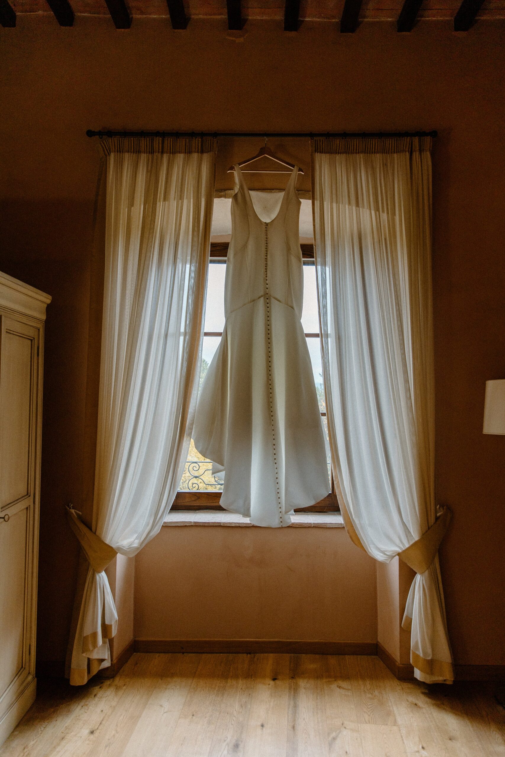 Elopement Dress hanging in the window at Castello di Baccaresca in Italy