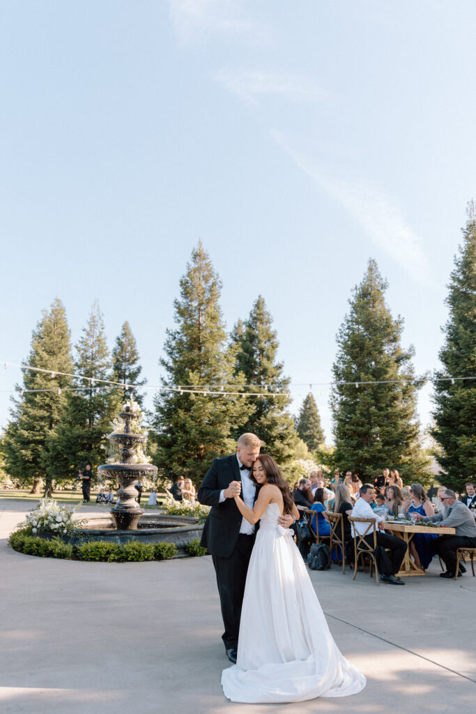 First Dance for wedding couple at The Ranch at Lone Oak Longhorns with fountain in the background