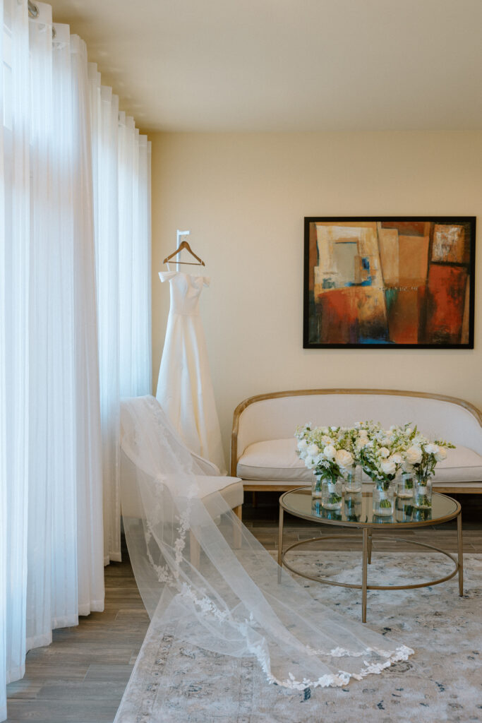 bridal getting ready room with wedding dress, veil and bouquets