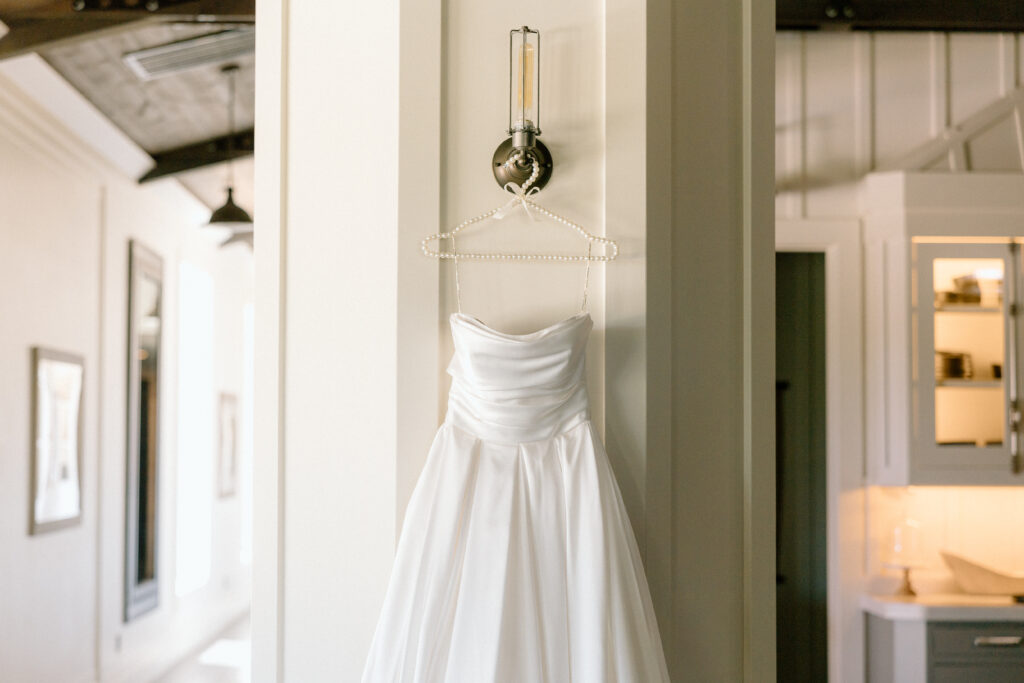 Wedding dress hanging photo on wedding day 