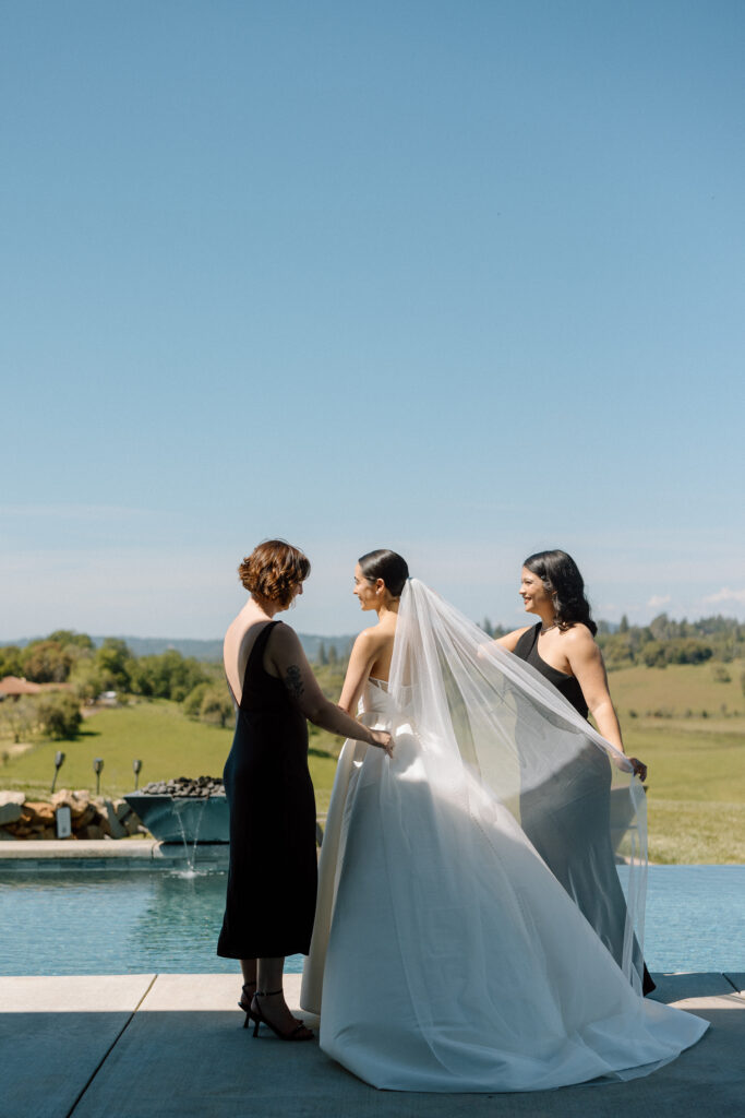 bridesmaids helping bride with veil on wedding day