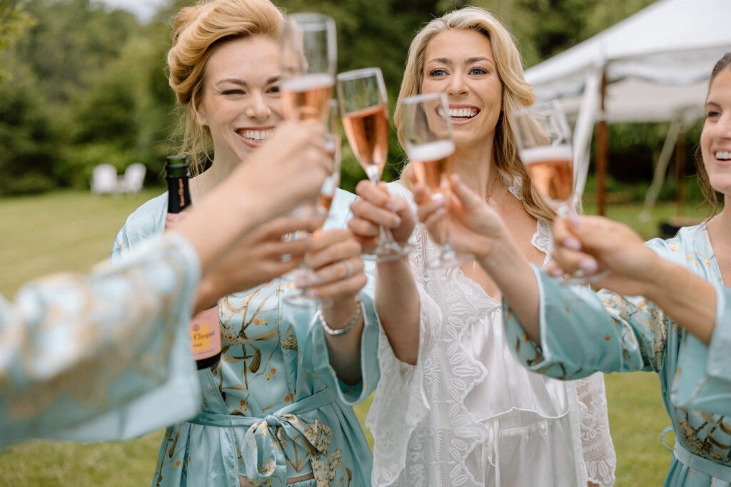 bride and bridesmaids drinking champagne on wedding morning