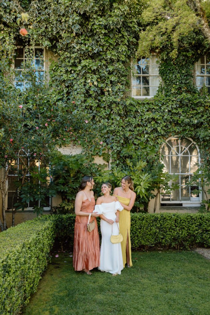 Bride and bridesmaids styled in European-inspired fashion, featuring rust and chartreuse dresses with vintage accessories at an editorial wedding at Château St. Jean.