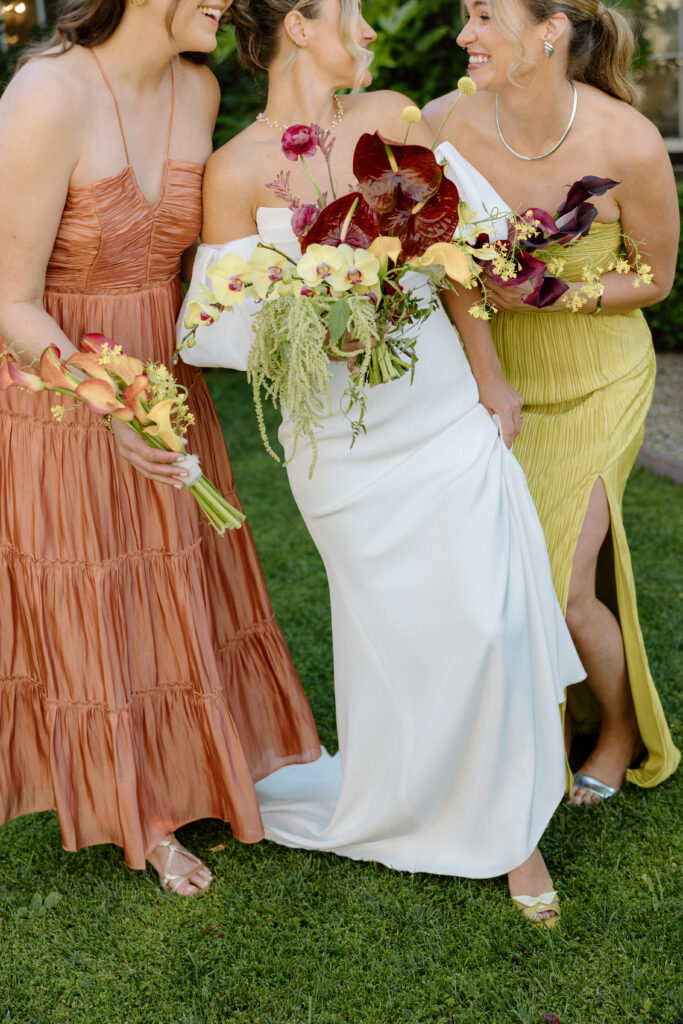 Bride and bridesmaids styled in European-inspired fashion, featuring rust and chartreuse dresses with vintage accessories at an editorial wedding at Château St. Jean.