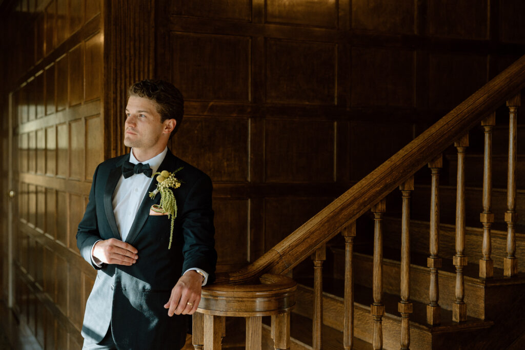 Groom styled in a classic black tuxedo with vintage Christian Dior silk bow tie, gold-etched cufflinks, and Bally loafers at a European-inspired wedding at Château St. Jean.