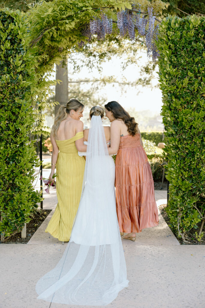 Bride and bridesmaids styled in European-inspired fashion, featuring rust and chartreuse dresses with vintage accessories at an editorial wedding at Château St. Jean.