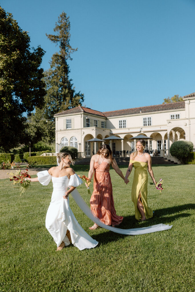 Bride and bridesmaids styled in European-inspired fashion, featuring rust and chartreuse dresses with vintage accessories at an editorial wedding at Château St. Jean.