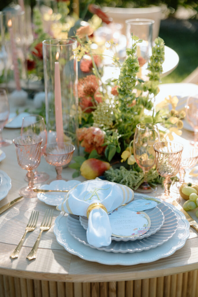Amalfi Coast–inspired wedding tablescape at Château St. Jean featuring yellow striped linens, fresh citrus, embroidered monogram napkins, and lush floral design