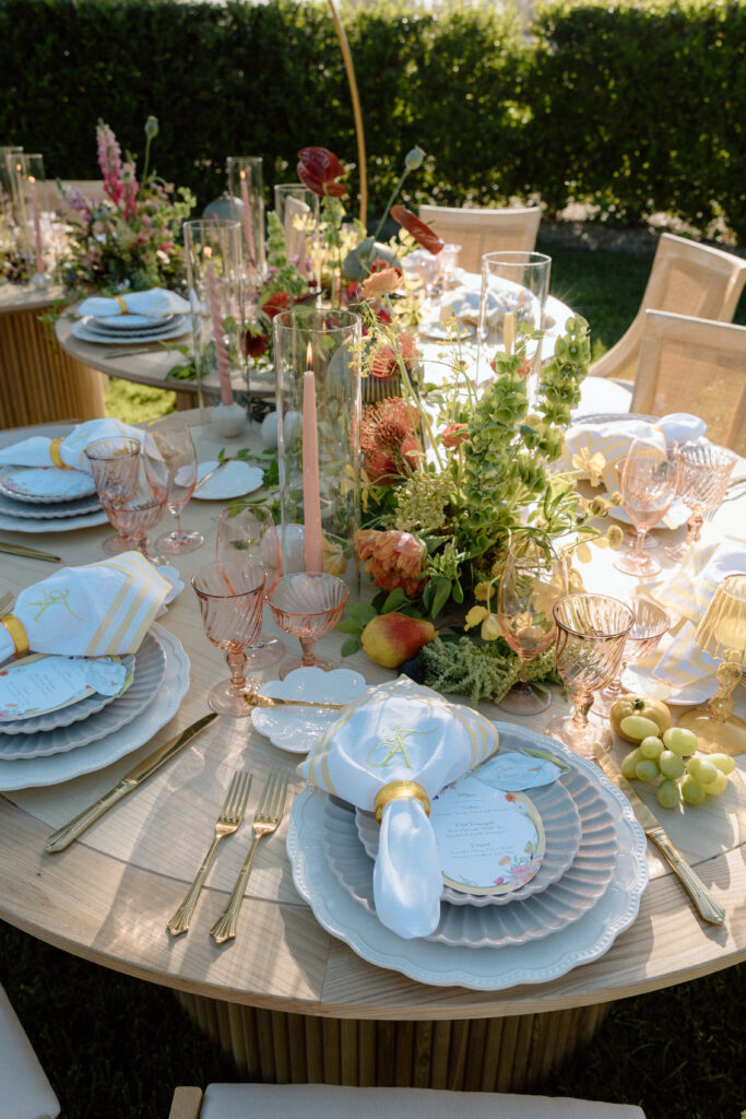 Amalfi Coast–inspired wedding tablescape at Château St. Jean featuring yellow striped linens, fresh citrus, embroidered monogram napkins, and lush floral design