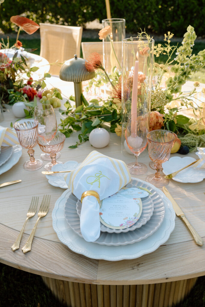 Amalfi Coast–inspired wedding tablescape at Château St. Jean featuring yellow striped linens, fresh citrus, embroidered monogram napkins, and lush floral design