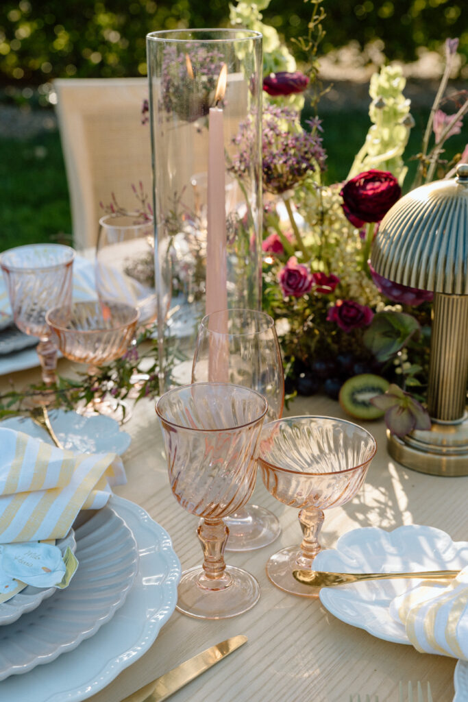 Amalfi Coast–inspired wedding tablescape at Château St. Jean featuring yellow striped linens, fresh citrus, embroidered monogram napkins, and lush floral design