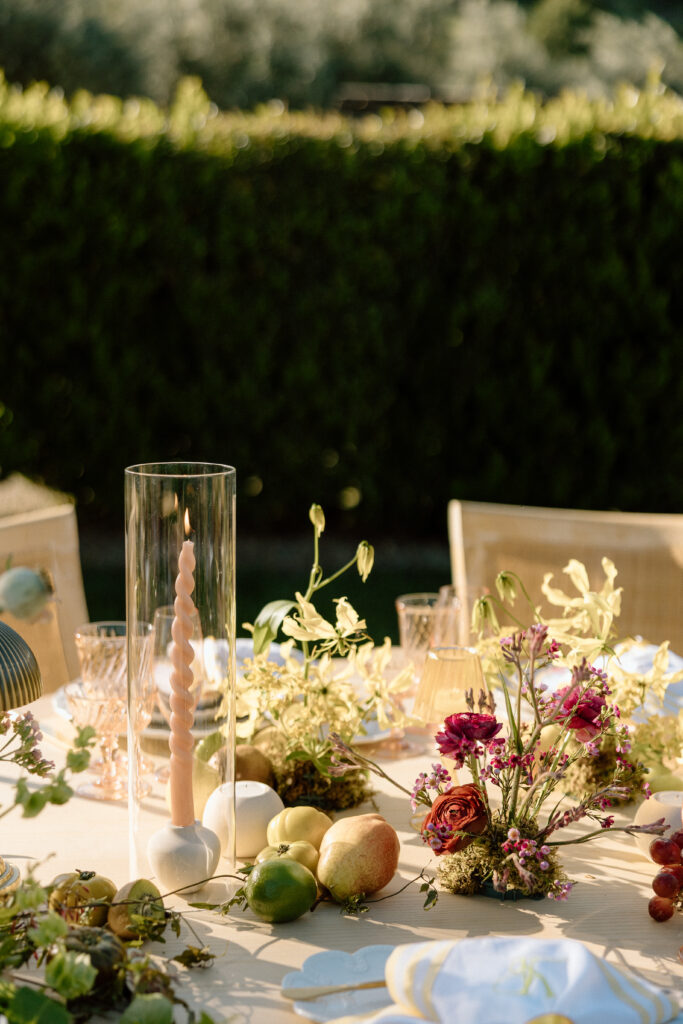 Amalfi Coast–inspired wedding tablescape at Château St. Jean featuring yellow striped linens, fresh citrus, embroidered monogram napkins, and lush floral design