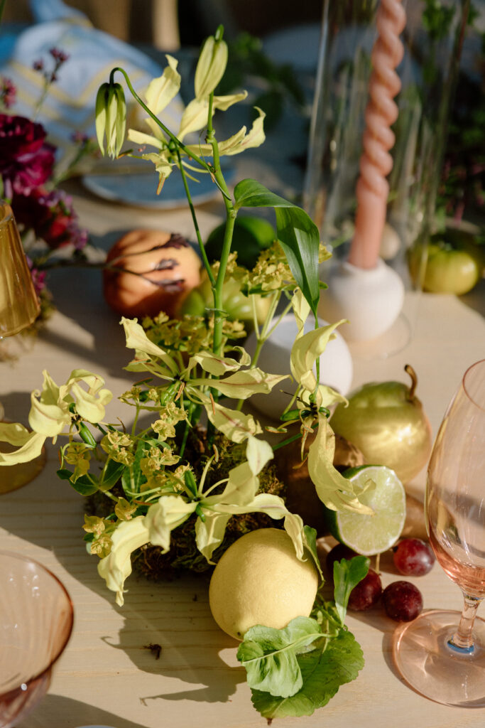 Amalfi Coast–inspired wedding tablescape at Château St. Jean featuring yellow striped linens, fresh citrus, embroidered monogram napkins, and lush floral design