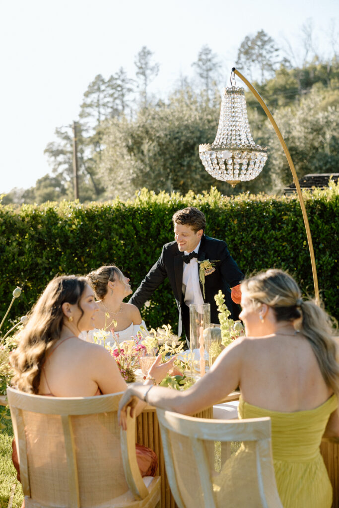 Amalfi Coast–inspired wedding tablescape at Château St. Jean featuring yellow striped linens, fresh citrus, embroidered monogram napkins, and lush floral design