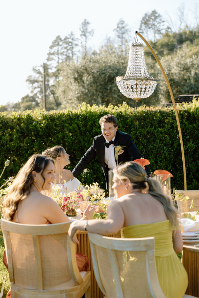 Amalfi Coast–inspired wedding tablescape at Château St. Jean featuring yellow striped linens, fresh citrus, embroidered monogram napkins, and lush floral design