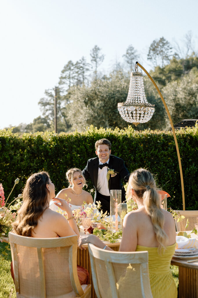 Amalfi Coast–inspired wedding tablescape at Château St. Jean featuring yellow striped linens, fresh citrus, embroidered monogram napkins, and lush floral design