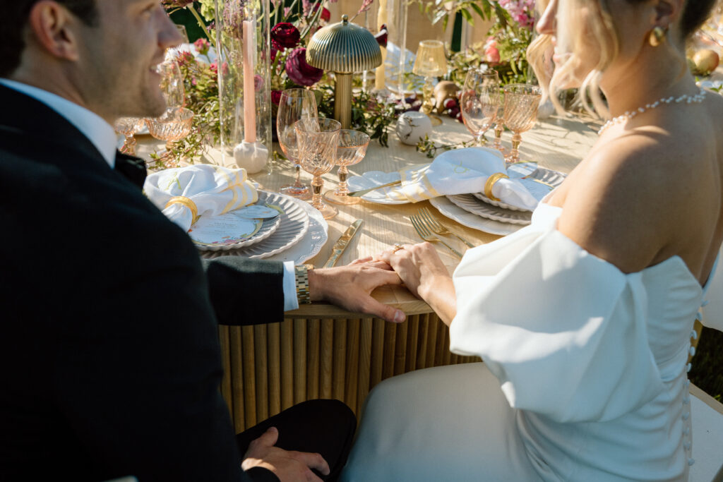 Amalfi Coast–inspired wedding tablescape at Château St. Jean featuring yellow striped linens, fresh citrus, embroidered monogram napkins, and lush floral design
