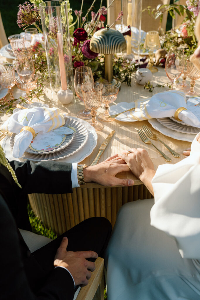 Amalfi Coast–inspired wedding tablescape at Château St. Jean featuring yellow striped linens, fresh citrus, embroidered monogram napkins, and lush floral design