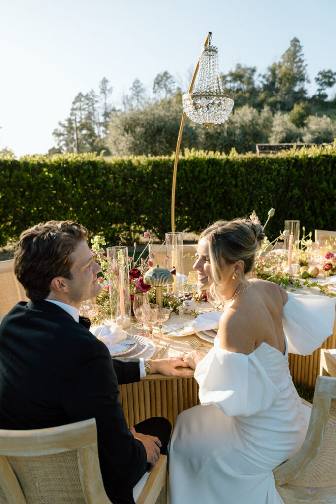 Amalfi Coast–inspired wedding tablescape at Château St. Jean featuring yellow striped linens, fresh citrus, embroidered monogram napkins, and lush floral design