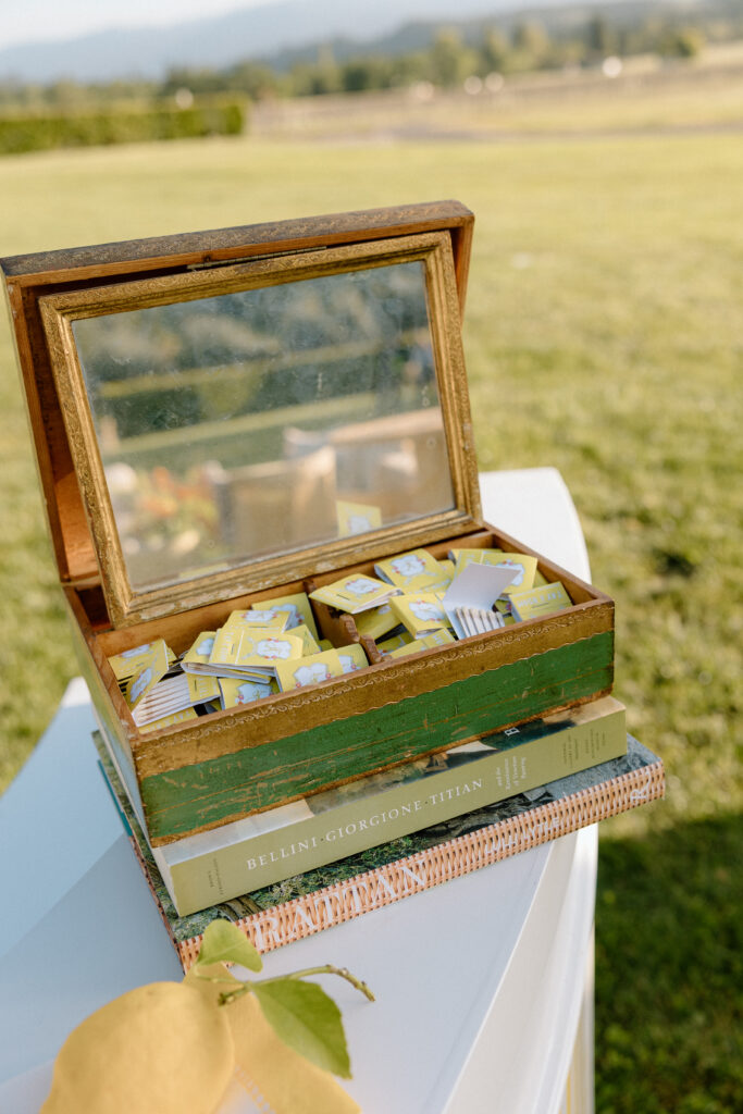 European-inspired wedding cocktail hour at Château St. Jean with citrus details, statement signage, striped linens, and a ‘ring for champagne’ moment in Sonoma Valley.