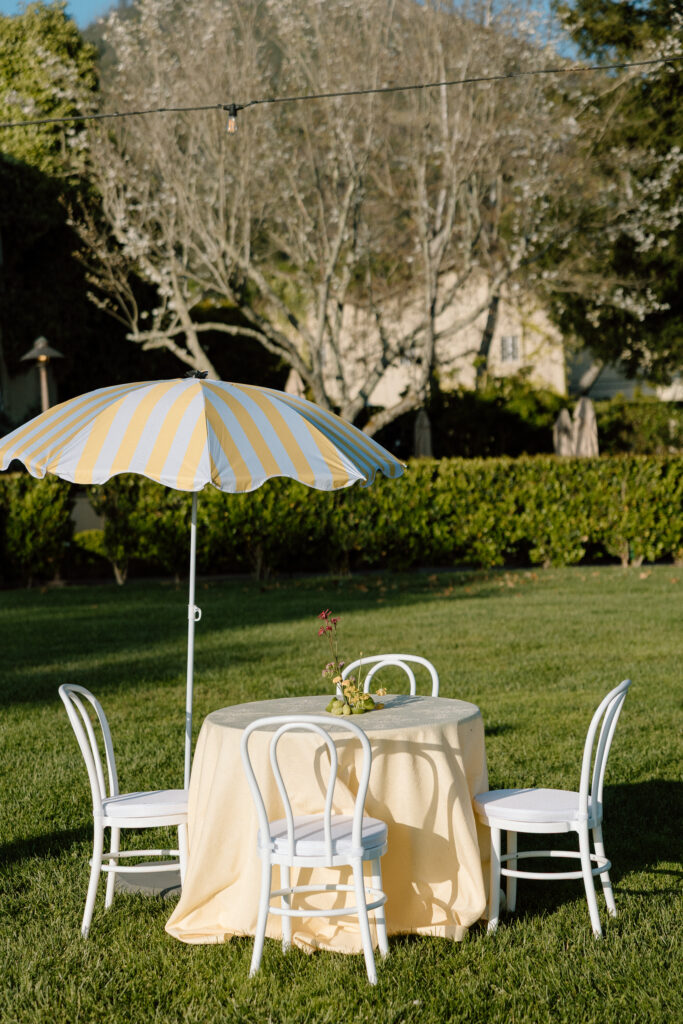 European-inspired wedding cocktail hour at Château St. Jean with citrus details, statement signage, striped linens, and a ‘ring for champagne’ moment in Sonoma Valley.