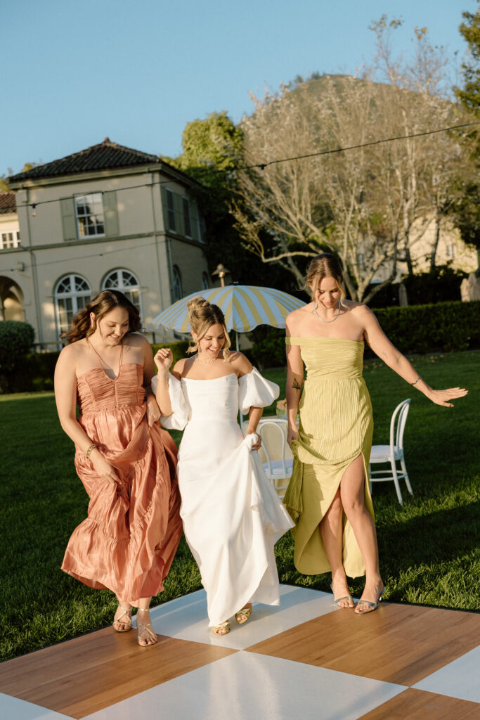 Bride and bridesmaids styled in European-inspired fashion, featuring rust and chartreuse dresses with vintage accessories at an editorial wedding at Château St. Jean.
