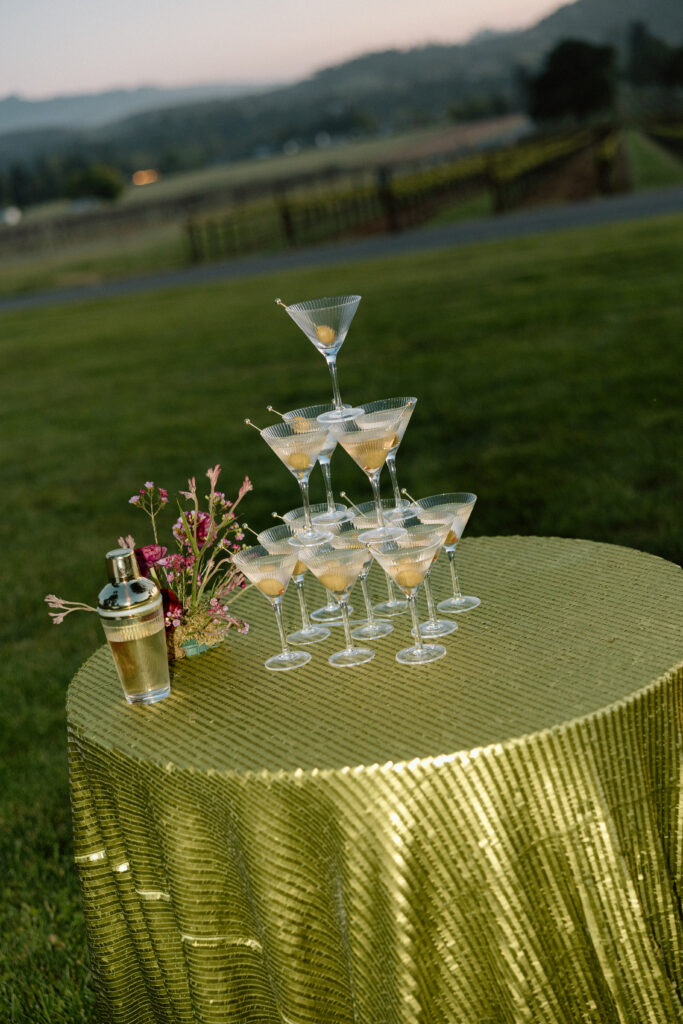 Bride wearing a modern satin mini dress and chartreuse heels during a martini tower celebration at a European-inspired California wedding at Château St. Jean.