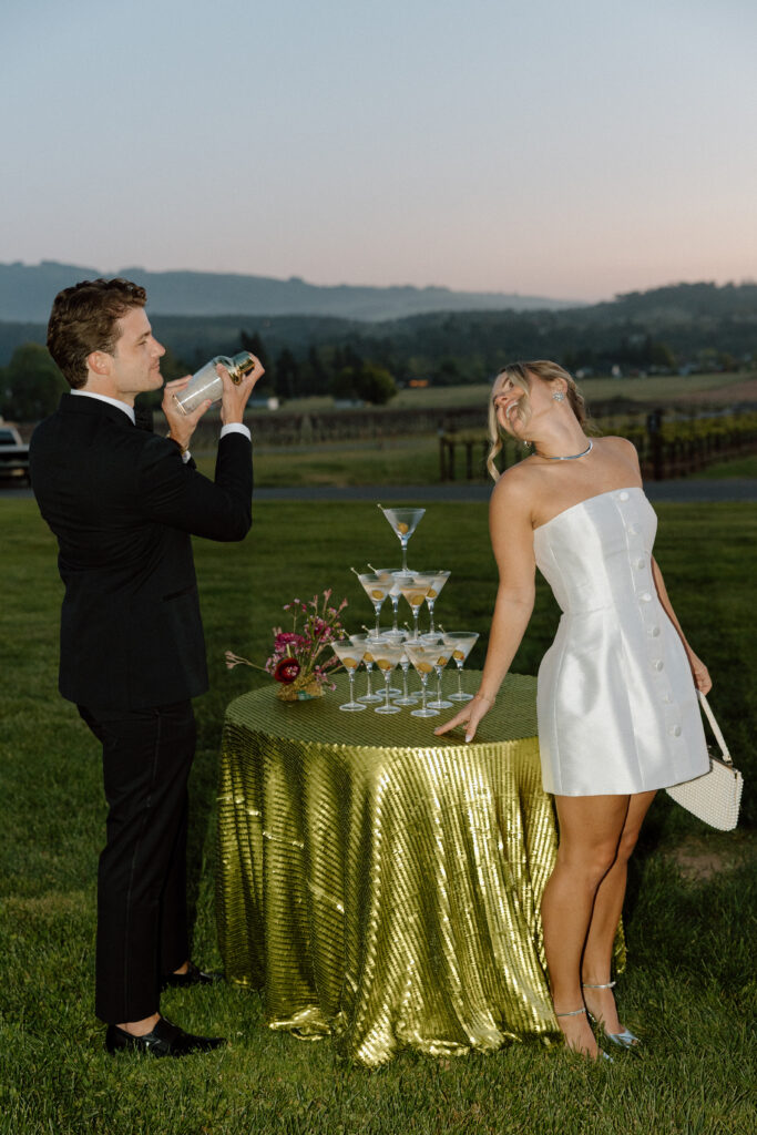 Bride wearing a modern satin mini dress and chartreuse heels during a martini tower celebration at a European-inspired California wedding at Château St. Jean.