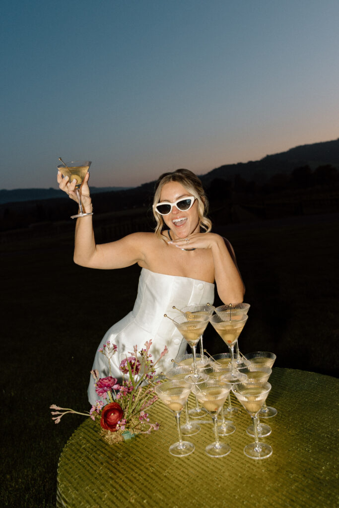 Bride wearing a modern satin mini dress and chartreuse heels during a martini tower celebration at a European-inspired California wedding at Château St. Jean.