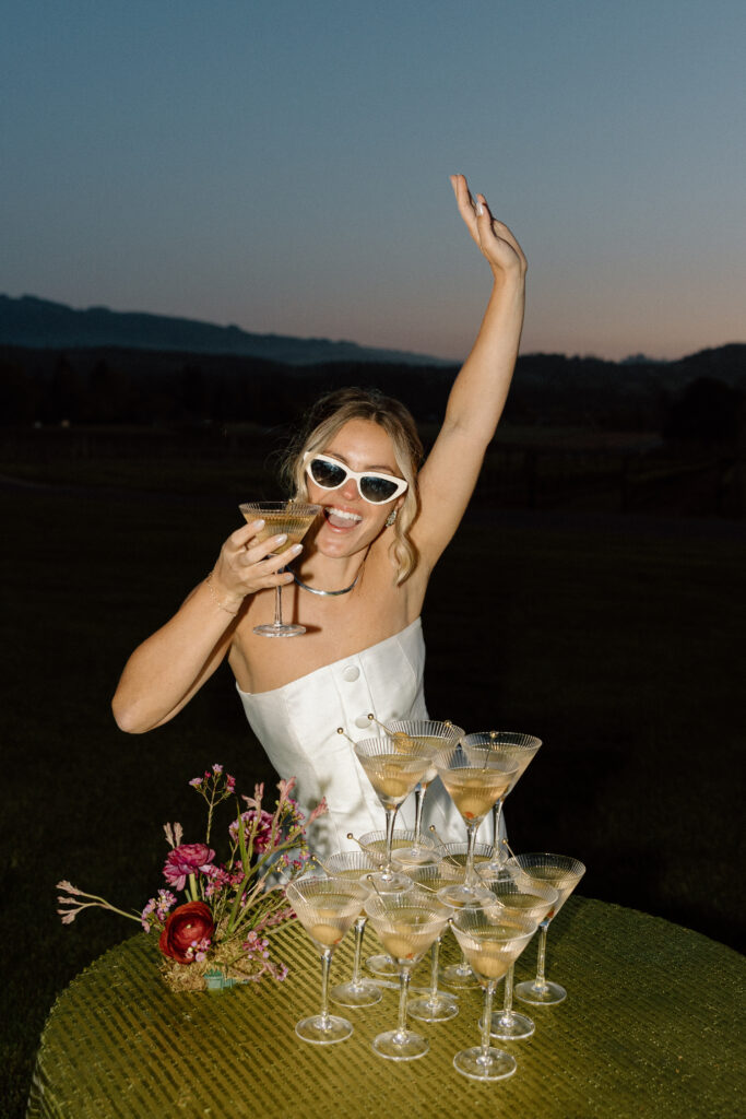 Bride wearing a modern satin mini dress and chartreuse heels during a martini tower celebration at a European-inspired California wedding at Château St. Jean.