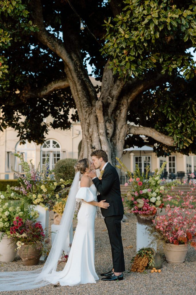 Romantic outdoor wedding ceremony at Château St. Jean with flowing florals, arched architecture, and vineyard backdrops inspired by European destination weddings.