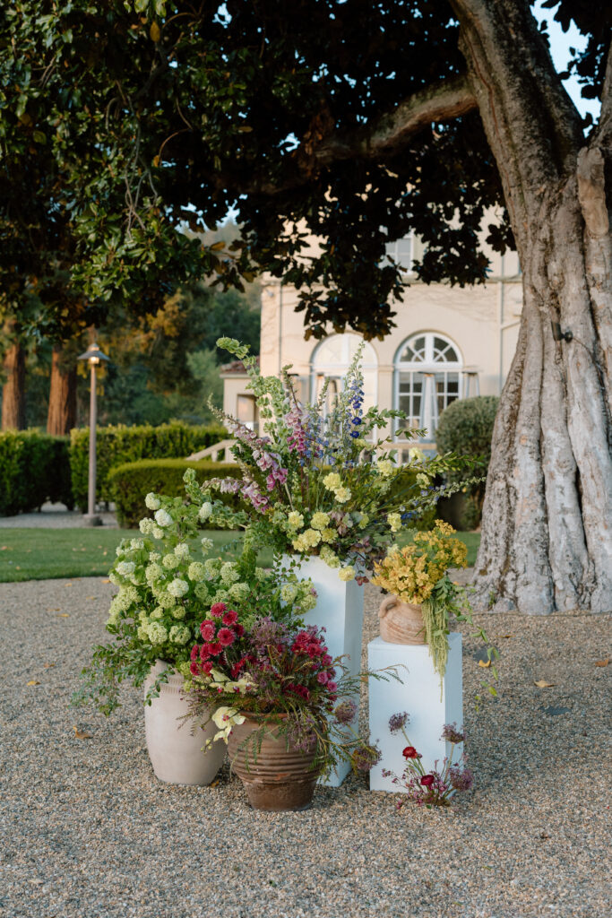 Romantic outdoor wedding ceremony at Château St. Jean with flowing florals, arched architecture, and vineyard backdrops inspired by European destination weddings.