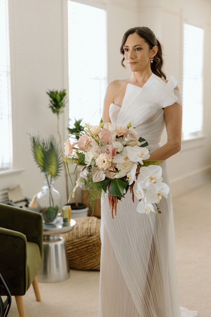 Bride getting ready with natural light pouring into the room before her Northern California sailboat wedding