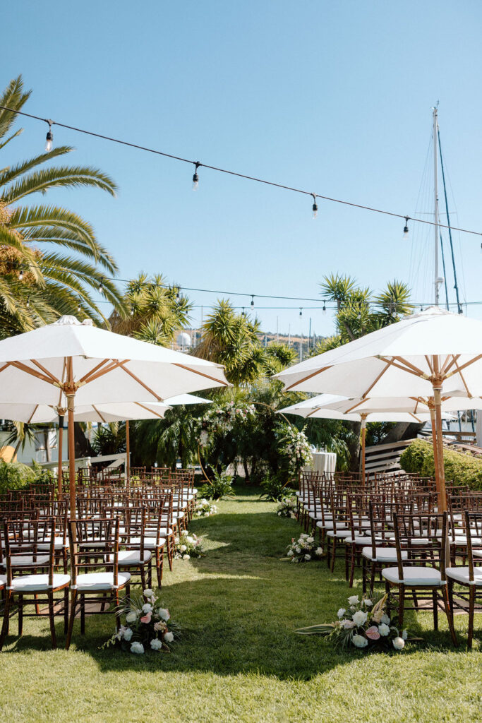 Bride and groom exchanging vows during an outdoor ceremony at Glen Cove Marina, surrounded by palm trees and sailboats in Northern California