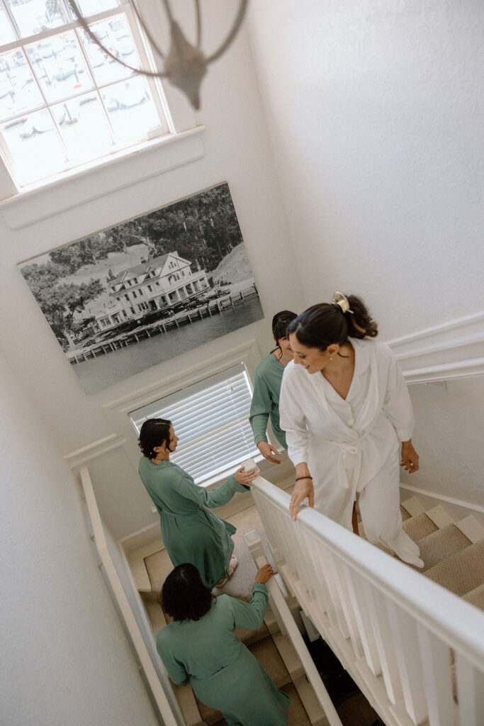 Bride getting ready with natural light pouring into the room before her Northern California sailboat wedding