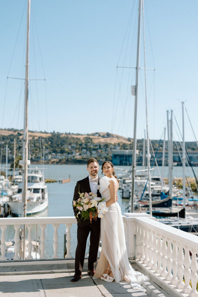 Bride and groom sharing their first look on a balcony overlooking sailboats at Glen Cove Marina