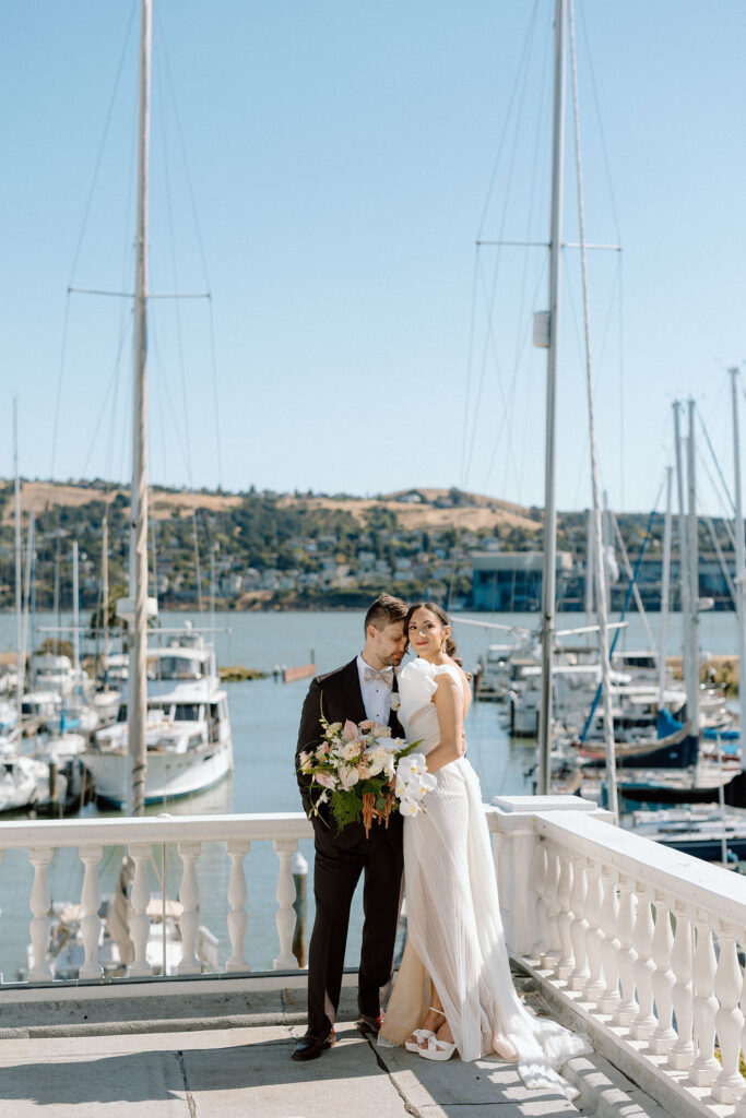 Bride and groom sharing their first look on a balcony overlooking sailboats at Glen Cove Marina