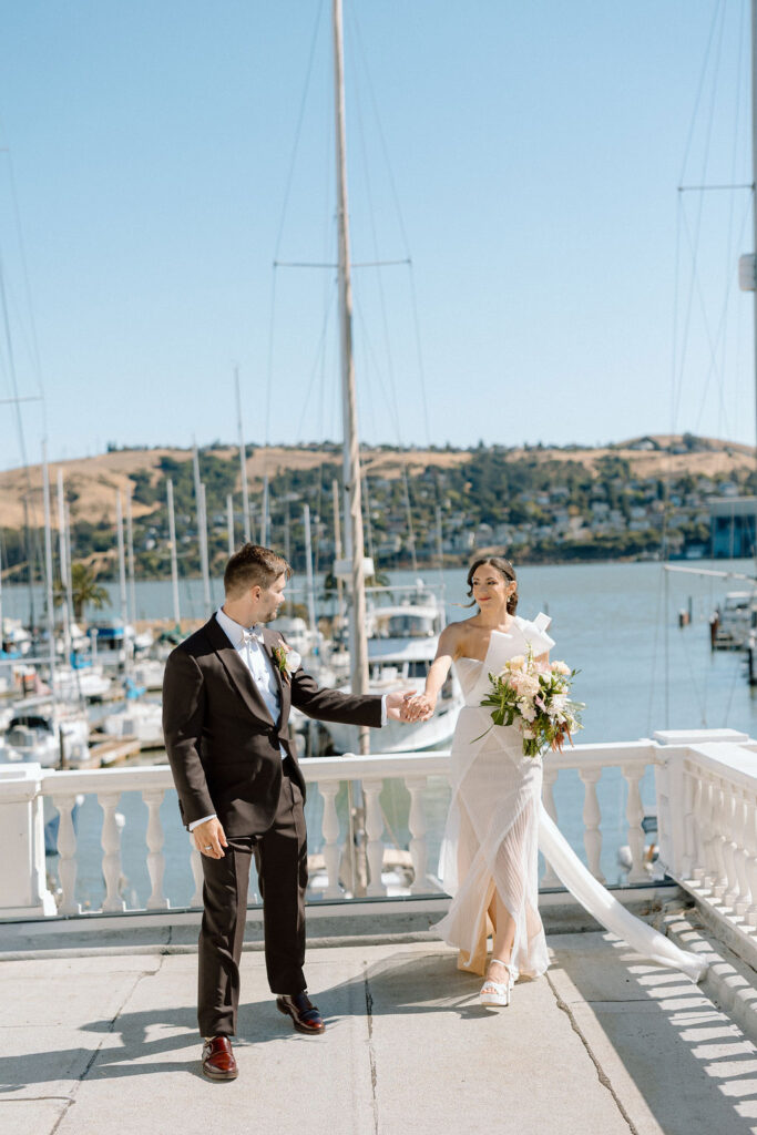 Bride and groom sharing their first look on a balcony overlooking sailboats at Glen Cove Marina