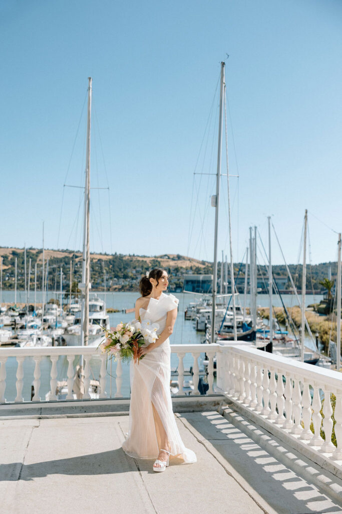 Bride and groom sharing their first look on a balcony overlooking sailboats at Glen Cove Marina