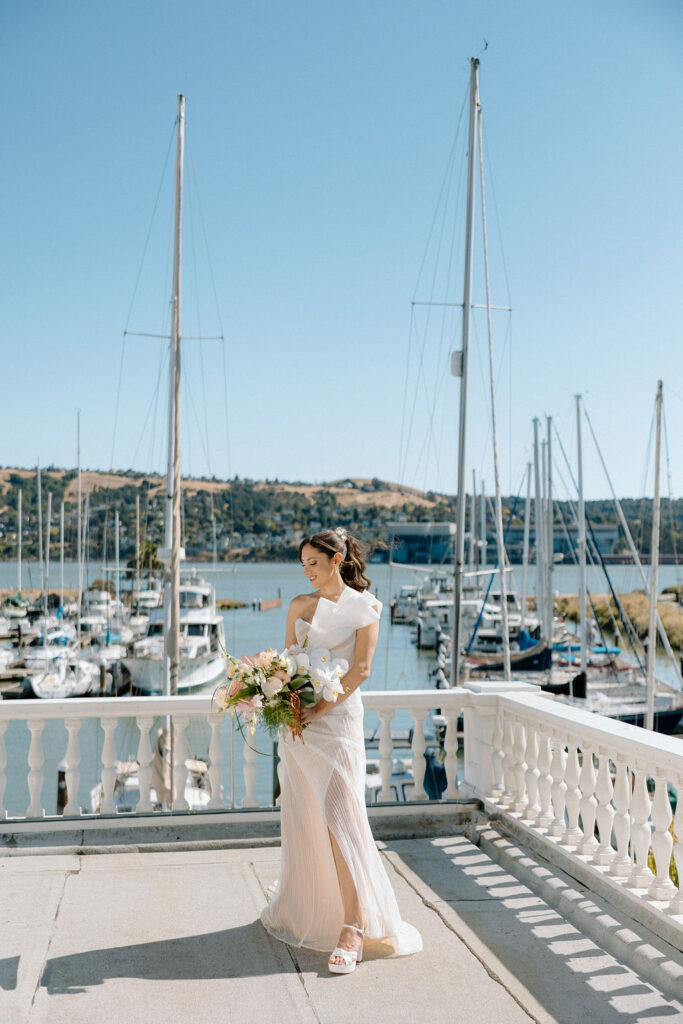 Bride and groom sharing their first look on a balcony overlooking sailboats at Glen Cove Marina