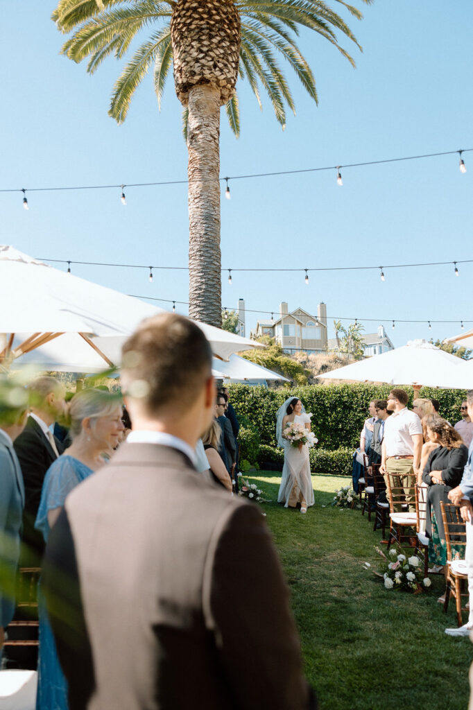 Bride and groom exchanging vows during an outdoor ceremony at Glen Cove Marina, surrounded by palm trees and sailboats in Northern California