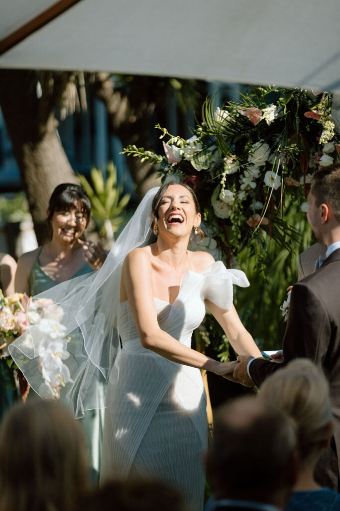 Bride and groom exchanging vows during an outdoor ceremony at Glen Cove Marina, surrounded by palm trees and sailboats in Northern California