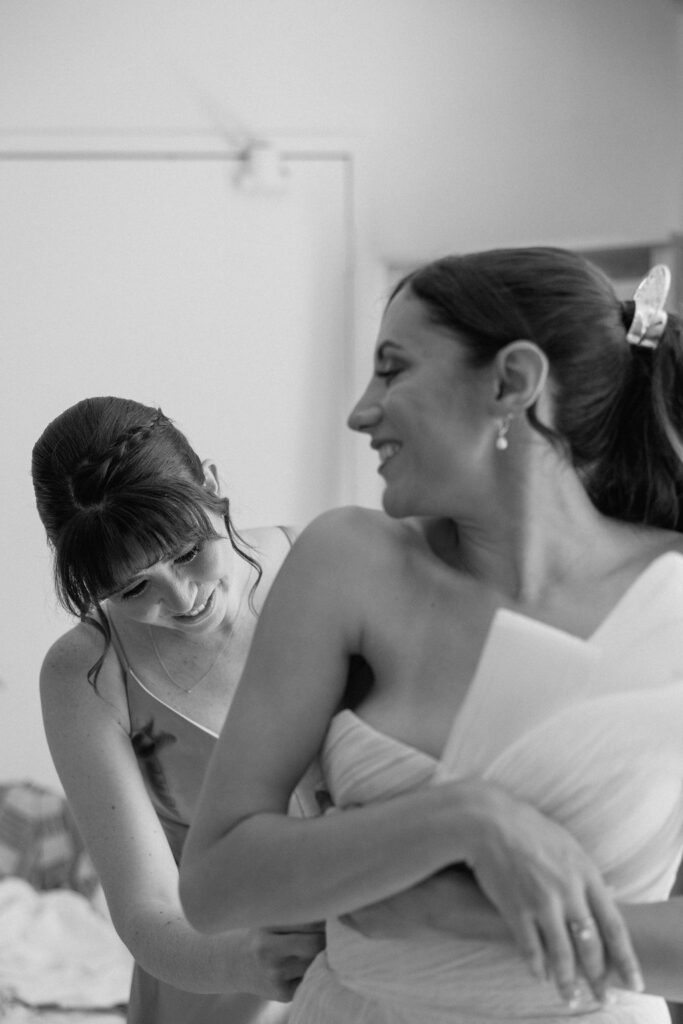 Bride getting ready with natural light pouring into the room before her Northern California sailboat wedding