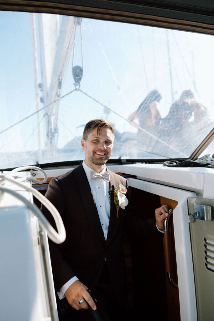 Newly married couple walking hand-in-hand from their ceremony to a sailboat dock at a Northern California marina wedding
