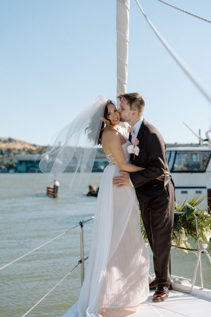 Bride and groom sailing together on San Francisco Bay after their wedding ceremony, enjoying a just-married cruise