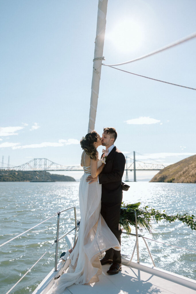 Bride and groom sailing together on San Francisco Bay after their wedding ceremony, enjoying a just-married cruise