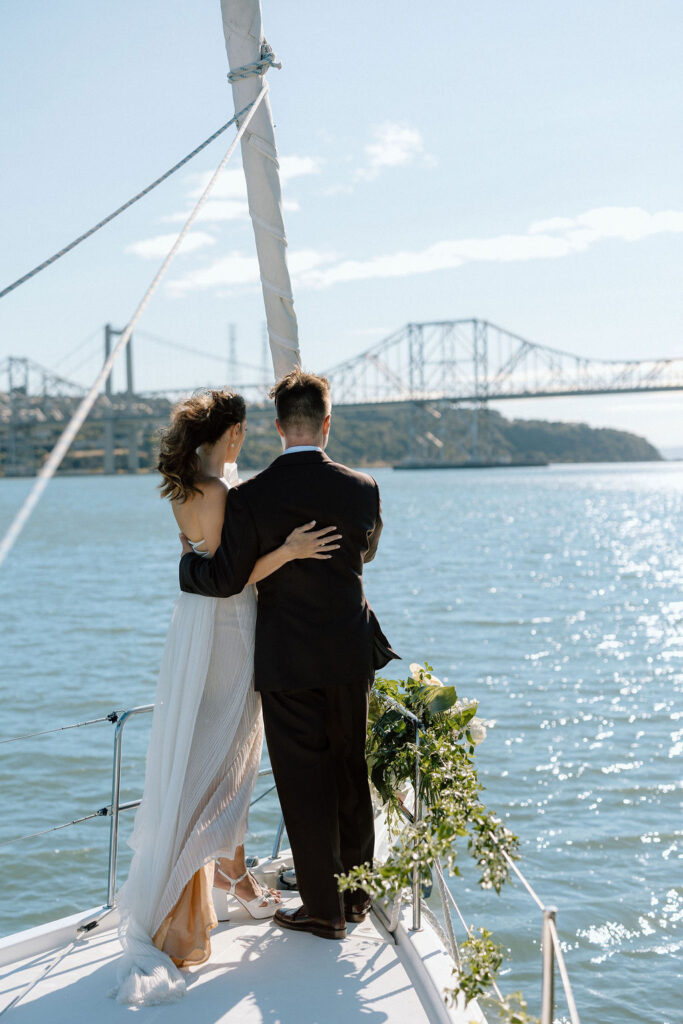 Bride and groom sailing together on San Francisco Bay after their wedding ceremony, enjoying a just-married cruise