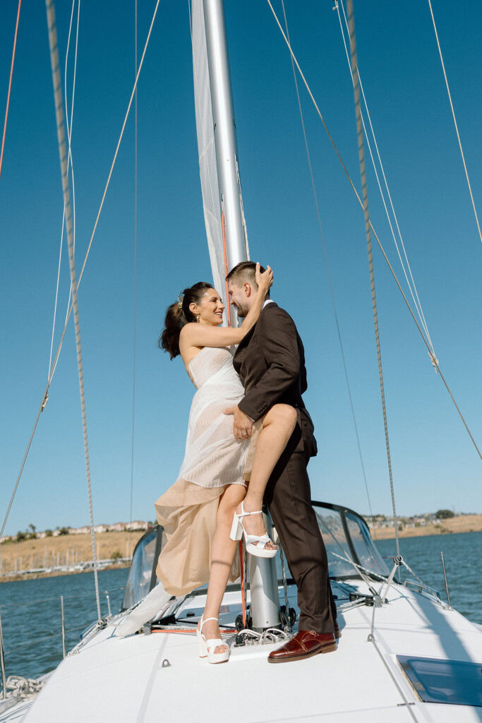 Bride wearing a flowing wedding gown in ocean breeze during a Northern California sailboat wedding