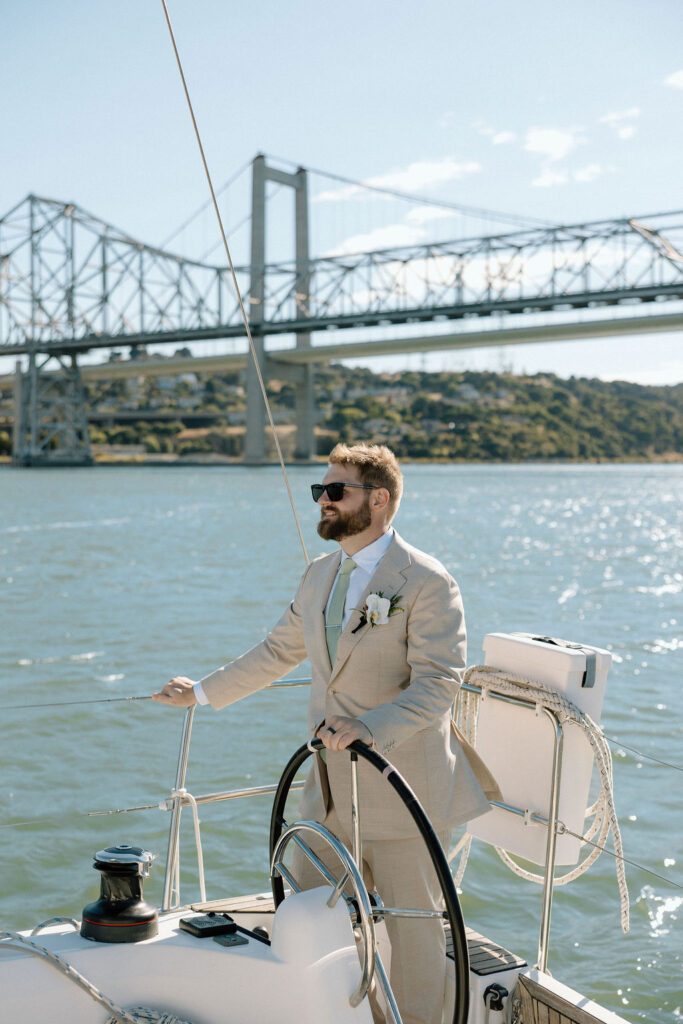 Bride wearing a flowing wedding gown in ocean breeze during a Northern California sailboat wedding
