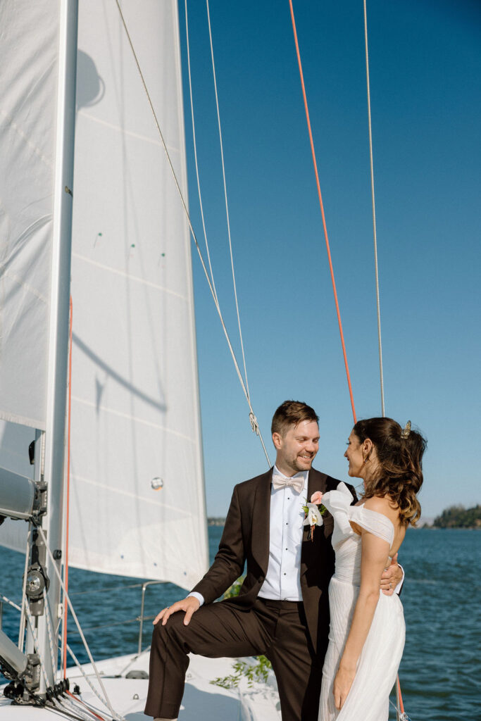 Bride wearing a flowing wedding gown in ocean breeze during a Northern California sailboat wedding